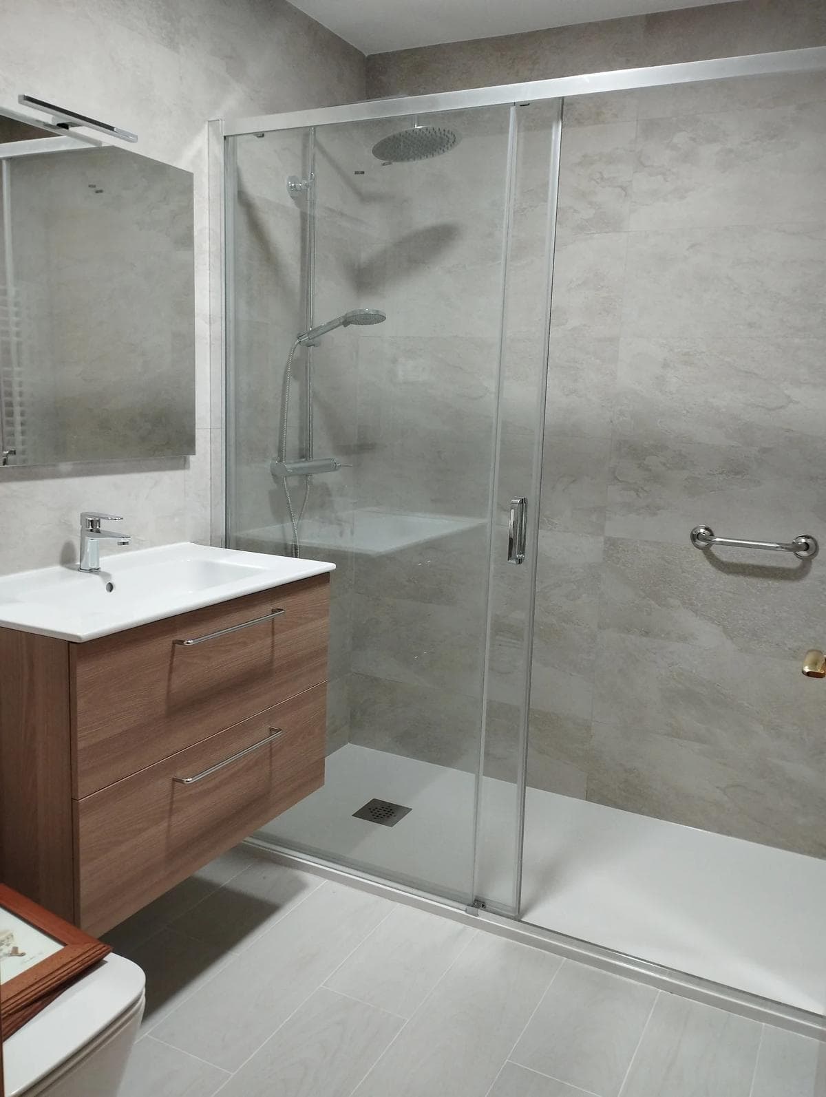 Baño moderno con plato de ducha y mampara instalado por Gracias Paco